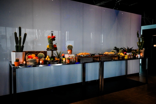 Long taco bar decorated with cacti.