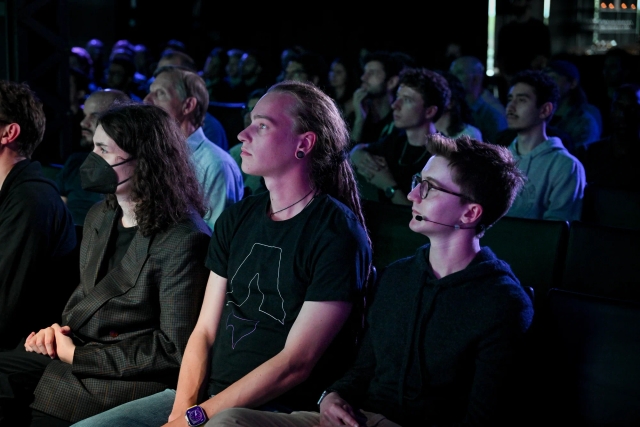 View of the front row audience members watching Fred K. Schott speak on stage.